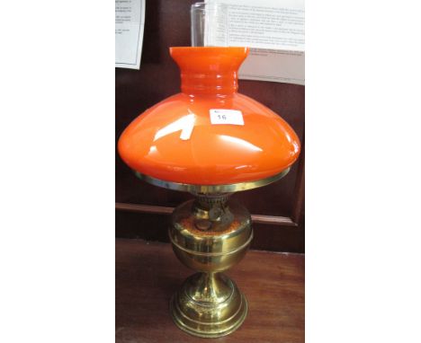 Brass double burner oil lamp with brass reservoir and pedestal base, coloured overlay glass shade and clear chimney. 