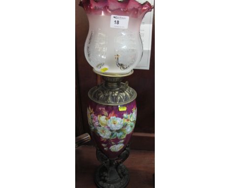 Late 19th century brass oil lamp with floral ceramic reservoir and bronzed metal claw shaped pedestal base, graduated etched 