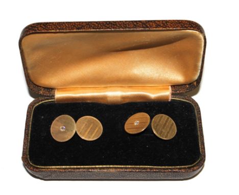 A pair of 14 carat gold cufflinks, engine turned decoration with a single diamond to the centre of one link