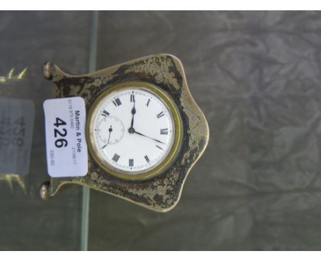 A silver cased bedside clock with brightcut decoration to case