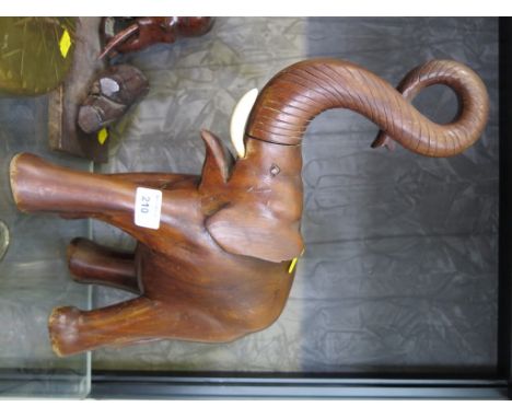 A carved hardwood elephant, the trunk held aloft, 39cm high