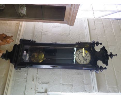An ebonised Vienna type wall clock, with enamelled dial, shaped pediment and moulded base, single train movement and subsidia