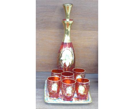 A continental red and gilt decorated decanter with six liqueur glasses and a metal tray