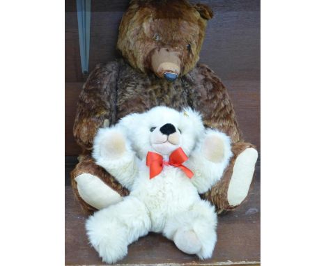 A large brown Teddy bear with pointed snout, hump back and jointed limbs and a small Steiff Teddy bear