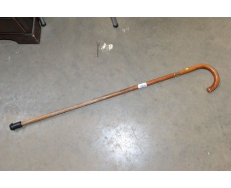 A yellow metal collared walking stick