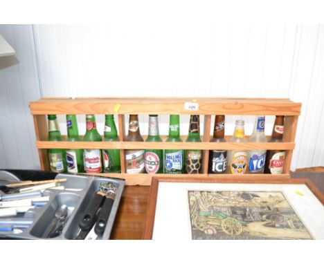 A wooden display shelf and contents of empty beer bottles