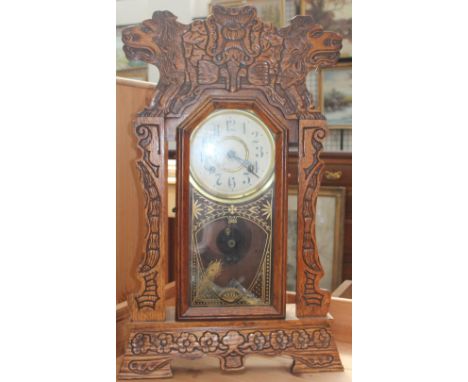 A New Haven Clock Co. 8 day Norwich Line striking mantle clock, carved with lion heads and a central flower head