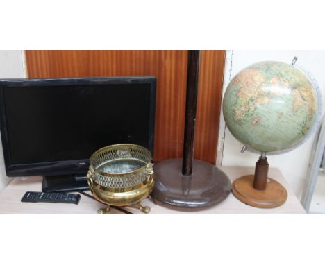 A Bush flat screen television (Sold as seen, untested) together with a standard lamp, a German printed globe and a brass plan