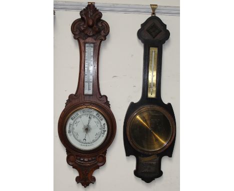 An oak cased aneroid barometer together with another oak cased barometer