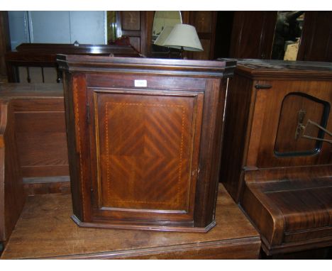 An Edwardian Mahogany wall hanging Corner Cupboard with moulded cornice, single panel door with quarter veneer and half herri