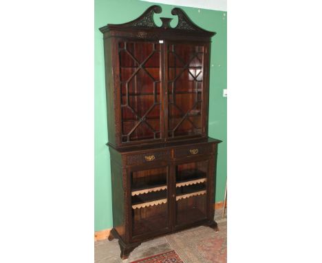 A late Victorian Chippendale revival style Mahogany Bookcase on Cupboard having delicate fret cut and pierced swan pediment t