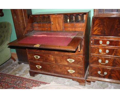 A Georgian Mahogany Bureau with plain top, the cross banded and boxwood and ebony strung fall opening to reveal eight pigeon 