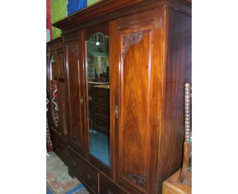 A late mid 19th c. Walnut double doored Wardrobe having wide moulded cornice over central long bevel plated arch top mirror, 