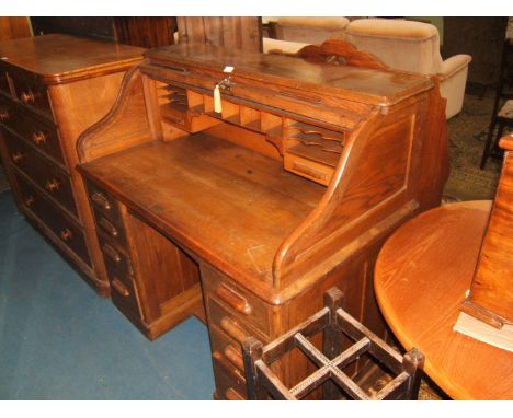 A Ministry Roll-top Kneehole Desk with moulded top, the tambour roller opening to reveal thirteen pigeon holes, two short dra