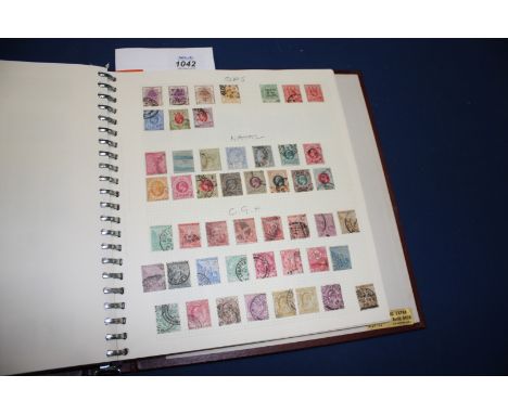 A red Stamp Album containing British Empire and Commonwealth Collection, Queen Victoria to George VII