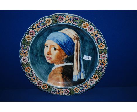 A large Delft hand-painted Charger depicting a portrait of a Young Girl, with floral border, 16 1/2" diameter