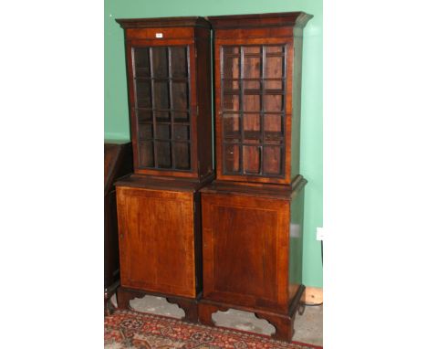A matched pair of George lll Mahogany narrow Bookcases having moulded cornice over twelve rectangular pane doors with moulded