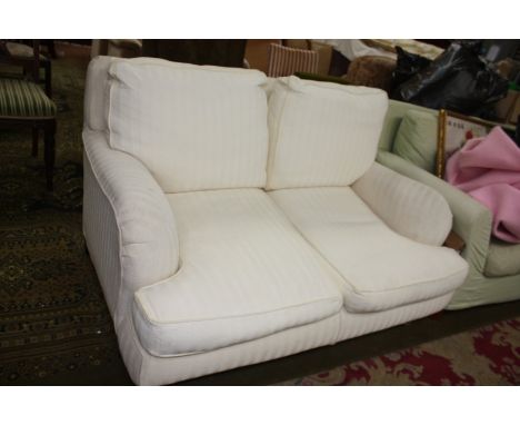 A modern two seater Sofa, four cushions in white shadow striped fabric upholstery, standing on short turned Mahogany finished