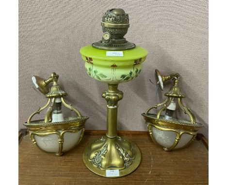 A brass and hand painted glass oil lamp and a pair of brass and opalescent glass ceiling lights 