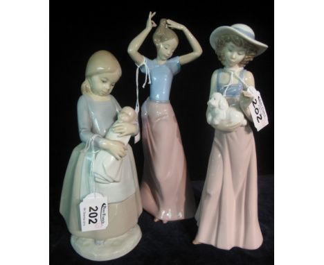 Three Nao Spanish porcelain figurines of girls, one with a baby. (3)(B.P. 24% incl. VAT)
