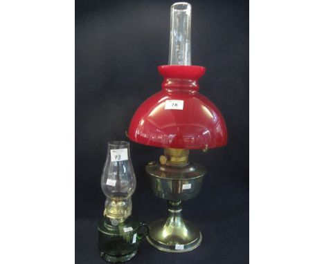 Plated oil lamp with overlay glass deep red shade and clear chimney, together with a green glass single burner chamber oil la
