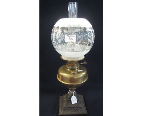 Brass baluster shaped oil lamp on cast metal base with etched glass shade and clear glass chimney. (B.P. 24% incl. VAT)