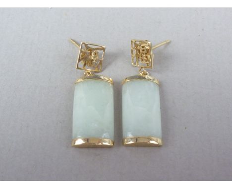 A pair of contemporary white jade and yellow metal pendant earrings, with Chinese character ear studs, and dependent convex r