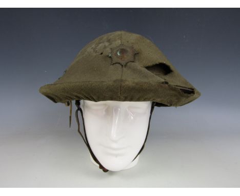 A First World War British Army 'Brodie' steel helmet bearing a fabric cover with affixed Coldstream Guards badge (chin strap 