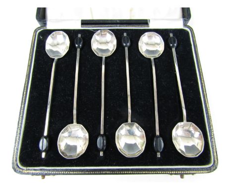 A cased set of six George VI silver coffee spoons, each having a streamline scallop shell bowl and black coffee bean finial, 