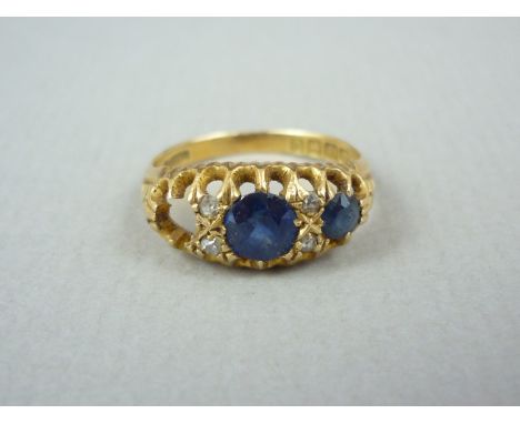 An early 20th Century three stone sapphire and diamond dress ring, the circular cut sapphires crown set in a graded arrangeme