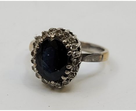 A white metal, diamond and sapphire cluster ring, set mixed oval cut sapphire to centre bordered by numerous eight-cut diamon