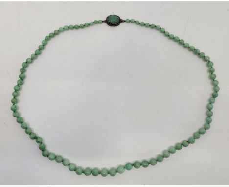 A Chinese graduated green jade necklace, the white metal clasp set carved jade beetle, the verso with impressed character mar