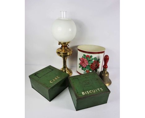 A brass hand bell, together with a brass column oil lamp, waste paper basket and two large painted biscuit tins (5)