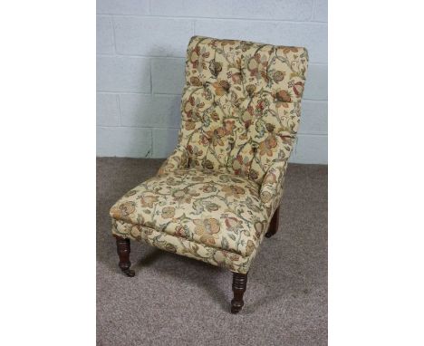 A Victorian mahogany and button upholstered easy chair, with turned front legs and castors