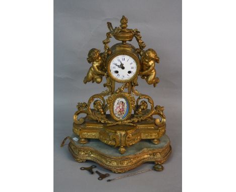 A MID 19TH CENTURY FRENCH GILT METAL MANTEL CLOCK, urn finial above the enamel dial with Roman and Arabic numerals (s.d.), fl