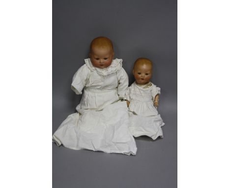 TWO ARMAND MARSEILLE BISQUE HEAD BABY DOLLS, first one nape of neck marked 'A.M. Germany' but other details are obscured by b