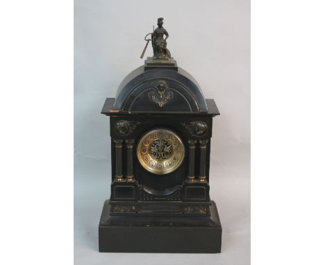 A LATE VICTORIAN BLACK SLATE MANTEL CLOCK, of architectural form, the domed top surmounted by a figure of seated classical wa