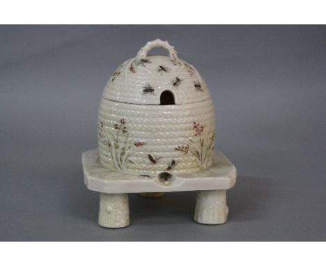 A BELLEEK FIRST PERIOD GRASS PATTERN HONEY POT AND COVER, in the form of a wicker skep on stand, blurred black printed mark, 