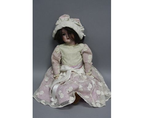 A SCHOENAU & HOFFMEISTER BISQUE HEAD DOLL, nape of neck marked with the star logo and '1909 5 1/2 Germany', with the two hole
