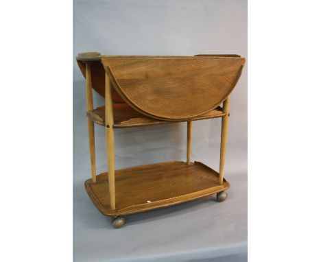 AN ERCOL BLONDE ELM THREE TIER DROP-LEAF SERVING TROLLEY, approximate width 73cm x depth 46cm x height 77cm, extended length 