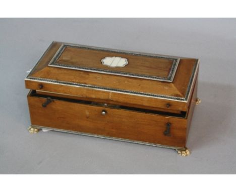 A 19TH CENTURY SANDALWOOD GAMES BOX, with ivory inlay to the hinged lid, on four ivory lion paw feet, the interior fitted wit