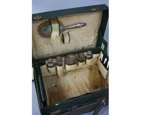 A GEORGE V HARRODS LTD GREEN LEATHER DRESSING CASE, peach silk liner (s.d.), incomplete contents, includes silver backed brus