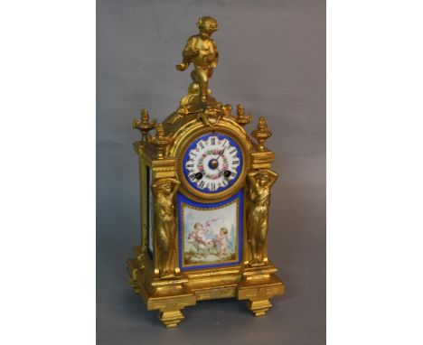 A MID 19TH CENTURY STYLE GILT METAL MANTEL CLOCK, putti surmounting an arched top with circular painted porcelain dial, Roman