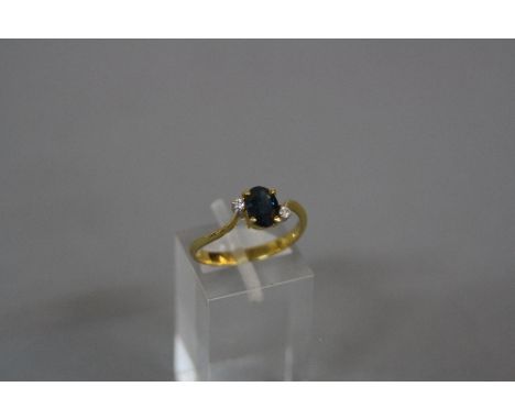 A MODERN SAPPHIRE AND DIAMOND THREE STONE TWIST DESIGN RING, one oval blue mixed cut sapphire measuring approximately 7mm x 5