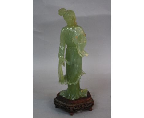 A LATE 19TH CENTURY CHINESE GREEN JADE FIGURE, of a lady wearing flowering robes (s.d.), together with a fitted carved wood s