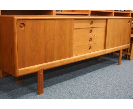 A LARGE DANISH TEAK SIDEBOARD, with four central long drawers flanked by single cupboards with sliding doors, one adjustable 