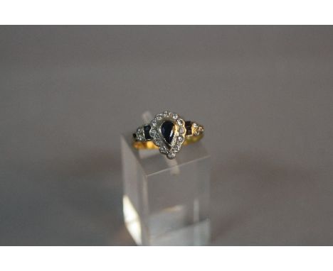 A LATE 20TH CENTURY 18CT GOLD SAPPHIRE AND DIAMOND PEAR SHAPE DRESS RING, a dark blue sapphire enclosed within a diamond bord