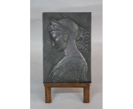 A LATE 19TH CENTURY EMBOSSED METAL PLAQUE, with bronzed finish, depicting head and shoulders portrait of a female saint in si