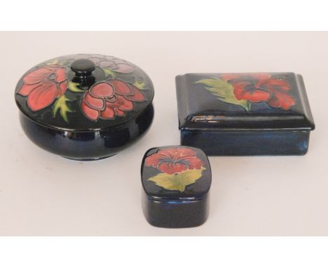 Three pieces of Moorcroft comprising an Anemone pattern powder bowl and cover, and two Hibiscus pattern trinket boxes, all wi