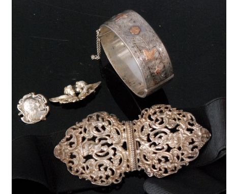 A hallmarked silver two piece nurses belt buckle, pierced and cast foliate decoration with C scrolls and cherubs heads all to